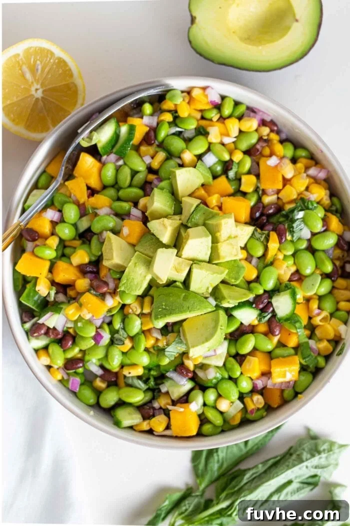 Tropical Mango Edamame Salad 6 A large bowl of salad with edamame, mango, cucumber and avocado, presented beautifully for serving.