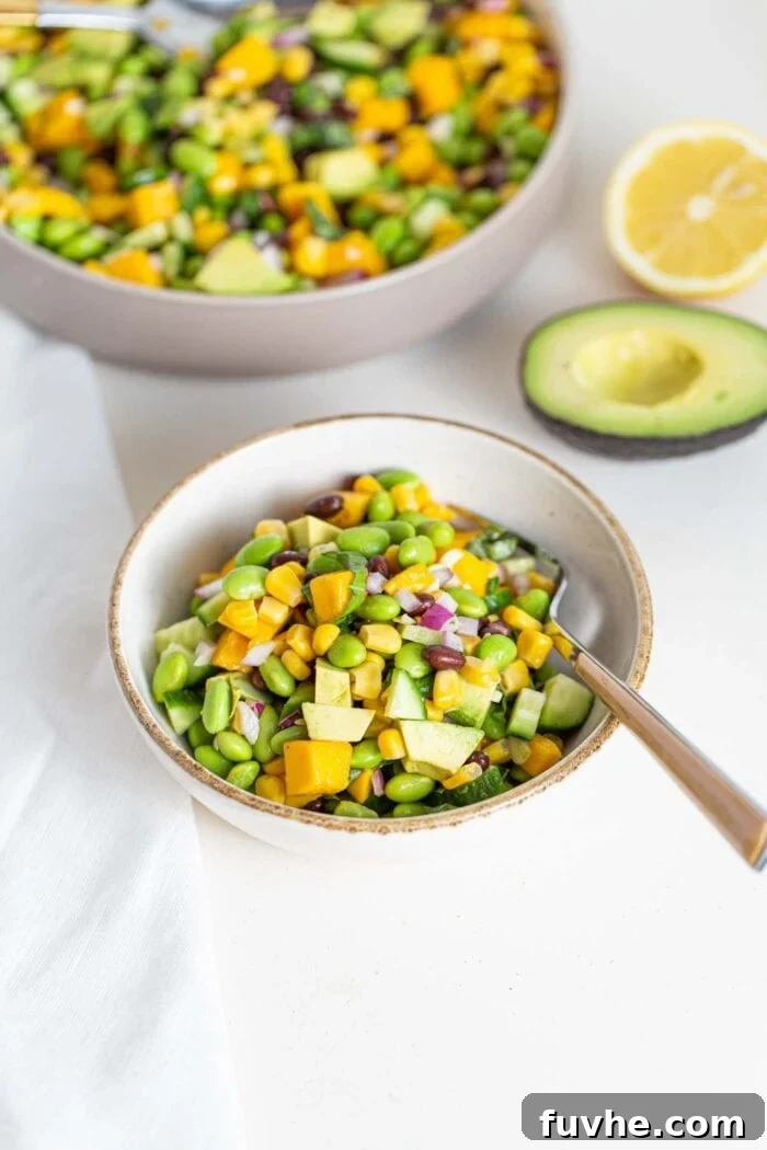 Tropical Mango Edamame Salad 7 A bowl of edamame, cucumber, avocado and mango salad, highlighting its fresh and inviting appearance.
