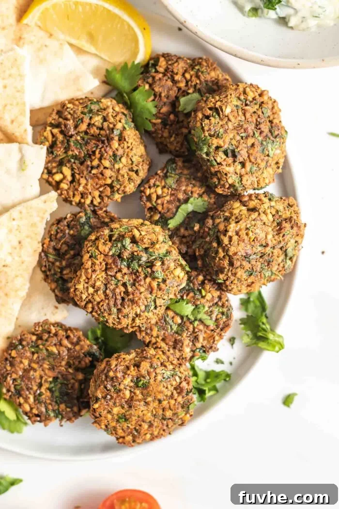 Golden Baked Falafel 2 A plate of golden, crispy baked falafel patties, garnished with fresh herbs.