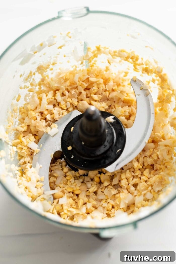Golden Baked Falafel 5 Coarsely blended chickpeas and onion mixture in a food processor, showing the ideal grainy texture.