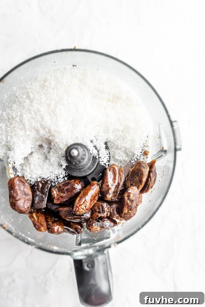 Decadent Plant-Based Chocolate Coconut Squares 3 Pitted dates, melted coconut oil, and unsweetened shredded coconut ready to be processed in a food processor.