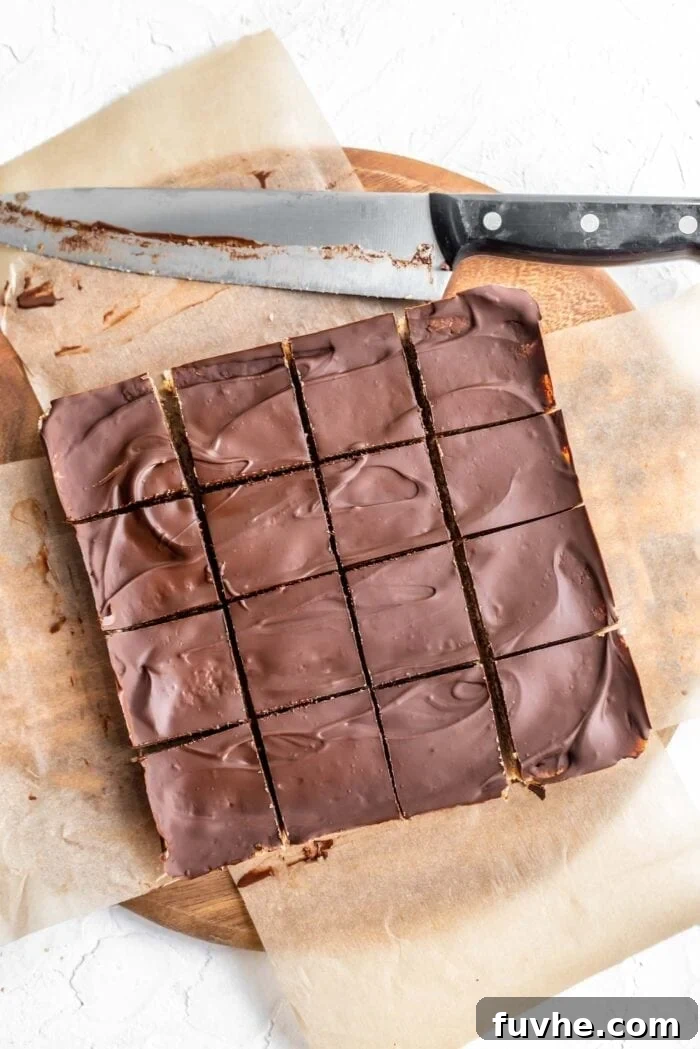 Decadent Plant-Based Chocolate Coconut Squares 9 Overhead shot of perfectly sliced chocolate coconut bars arranged into 16 square pieces, showcasing the distinct layers.