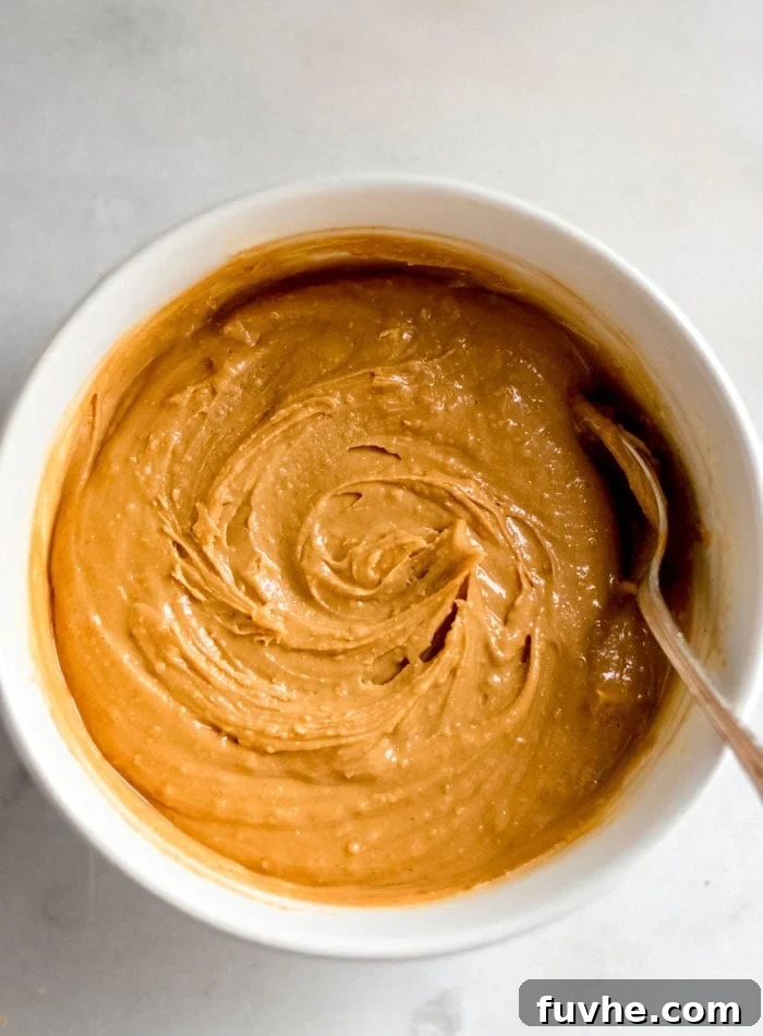 Smooth peanut butter filling in a mixing bowl with a spoon, showing its creamy texture.