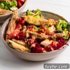 An overhead view of a colorful vegan dragon bowl, generously topped with a creamy sauce and ready to be enjoyed.