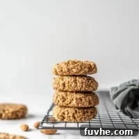 Stack of gluten-free vegan coconut almond date cookies sitting on a cooling rack.