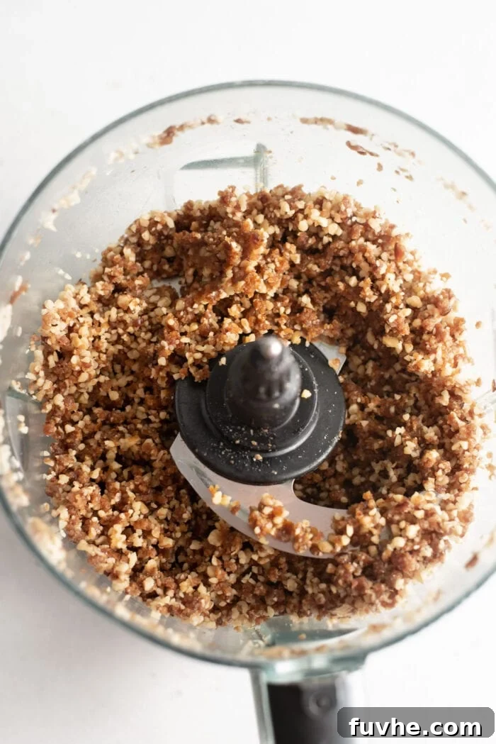 Easy Vegan No-Bake Pumpkin Cheesecake 4 A crumbly but sticky date and walnut crust mixture in a food processor, ready to be pressed into the pan.