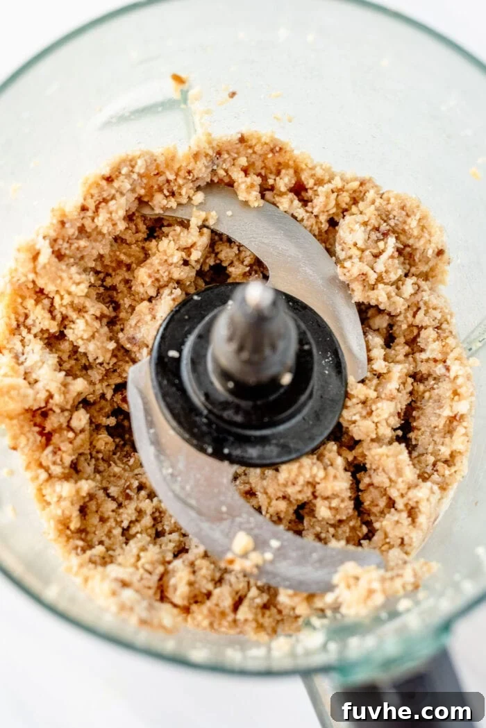 Crumbly dough made of dates, coconut and cashews in a food processor.