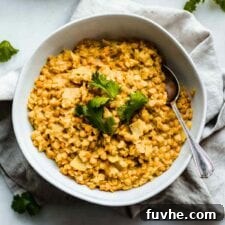 A bowl of red lentil dahl topped with fresh cilantro, photographed from above.