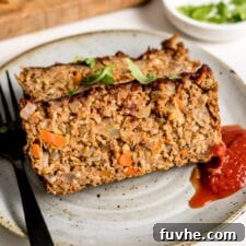 Delicious slices of vegan chickpea meatloaf with a tangy ketchup drizzle on a plate.