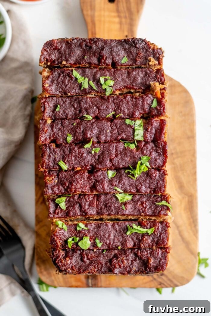 An inviting overhead shot of a freshly baked vegetarian meatloaf, expertly sliced on a wooden cutting board, showcasing its wholesome, textured interior.