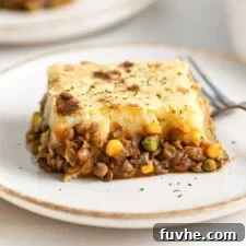 Comforting Vegan Lentil Shepherd's Pie 13 Large slice of lentil shepherd's pie on a plate, showcasing its golden mashed potato topping and rich filling.