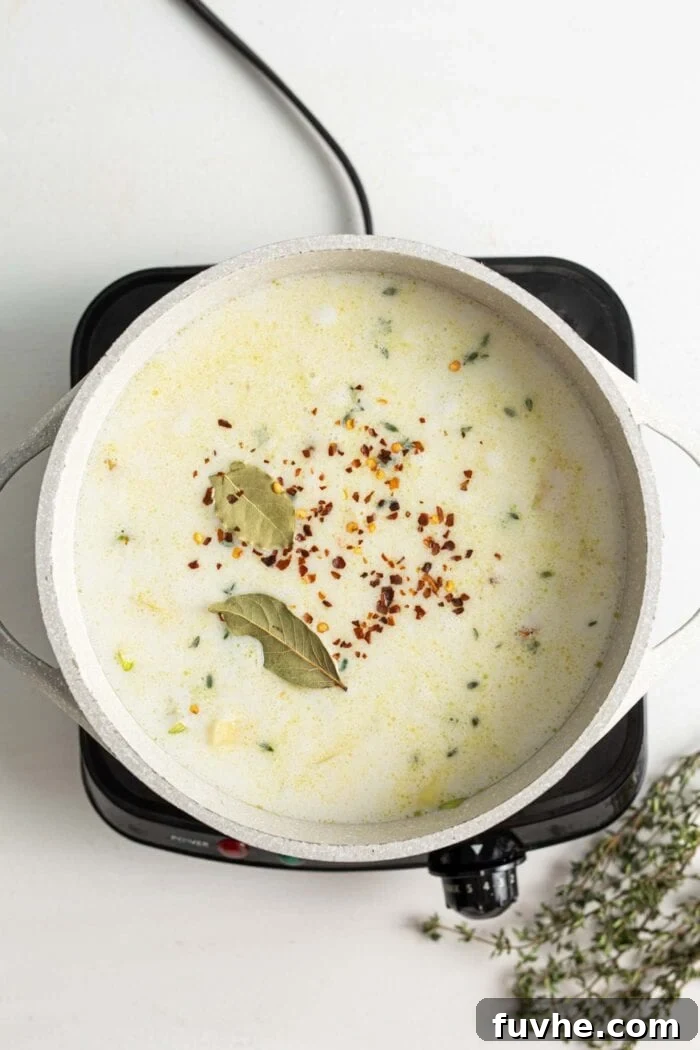 Creamy Vegan Potato Leek Soup 6 The creamy potato leek soup simmering gently in a large soup pot, its vibrant ingredients melding together.