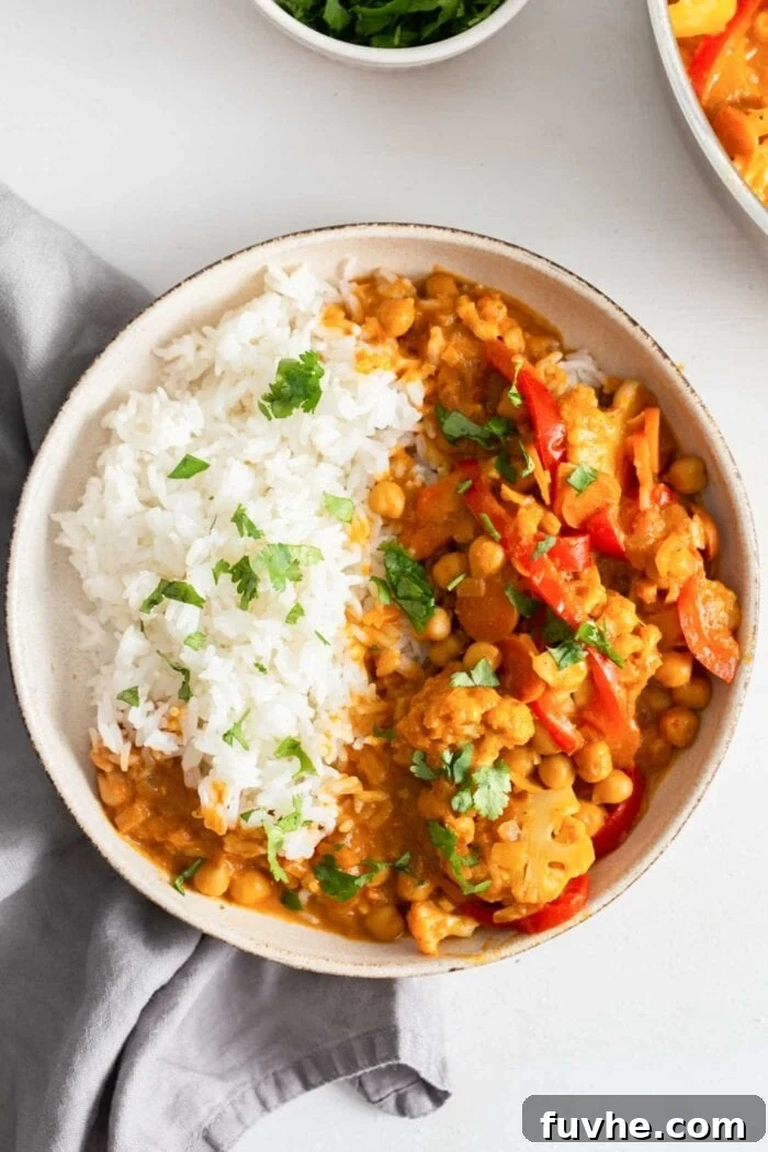 Bowl of white rice aside a cauliflower chickpea curry.