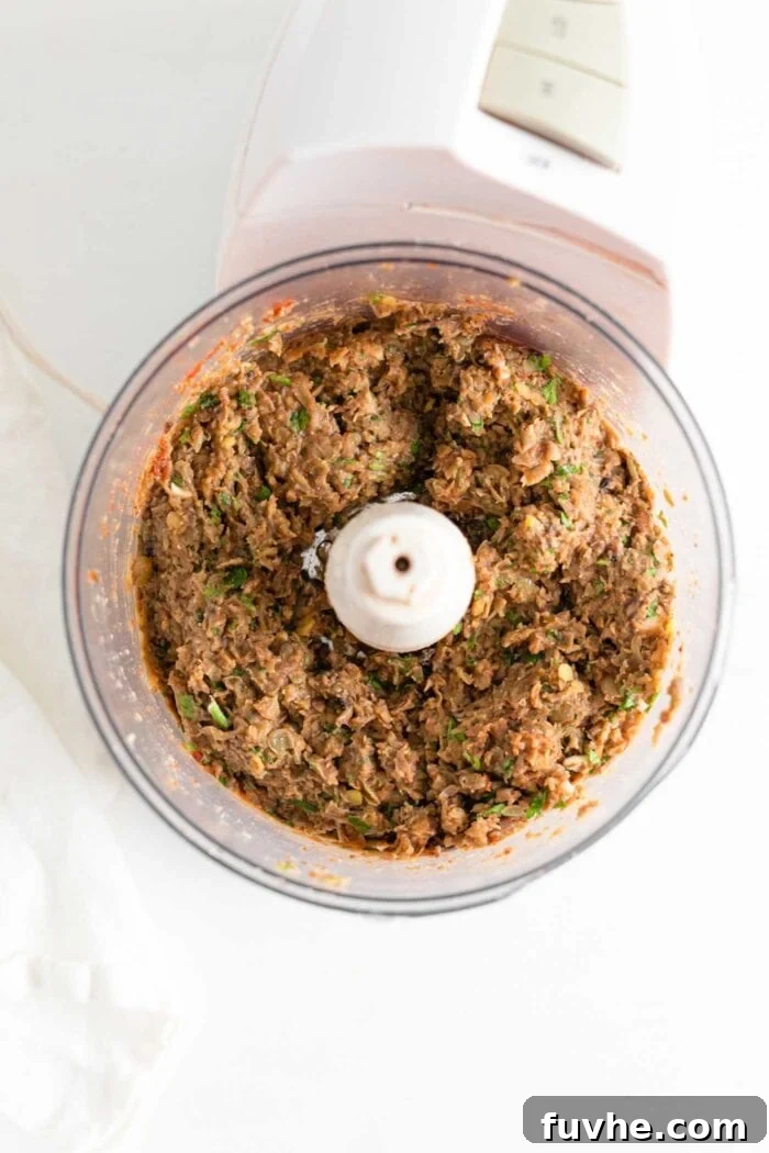 Savory Lentil Plantballs 6 A close-up view of the perfectly ground mixture of lentils and mushrooms inside a food processor bowl, ready to be formed into vegan meatballs.