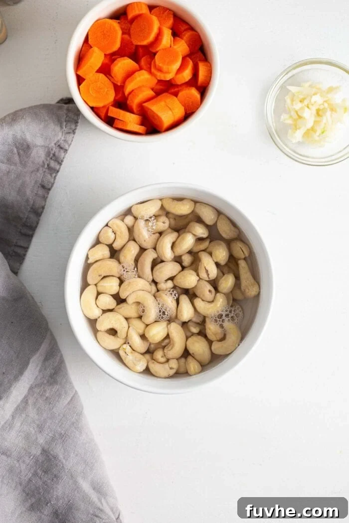 Creamy Vegan Vegetable Korma 4 Raw cashews soaking in a small white bowl filled with hot water, preparing them for blending into a smooth, creamy sauce.