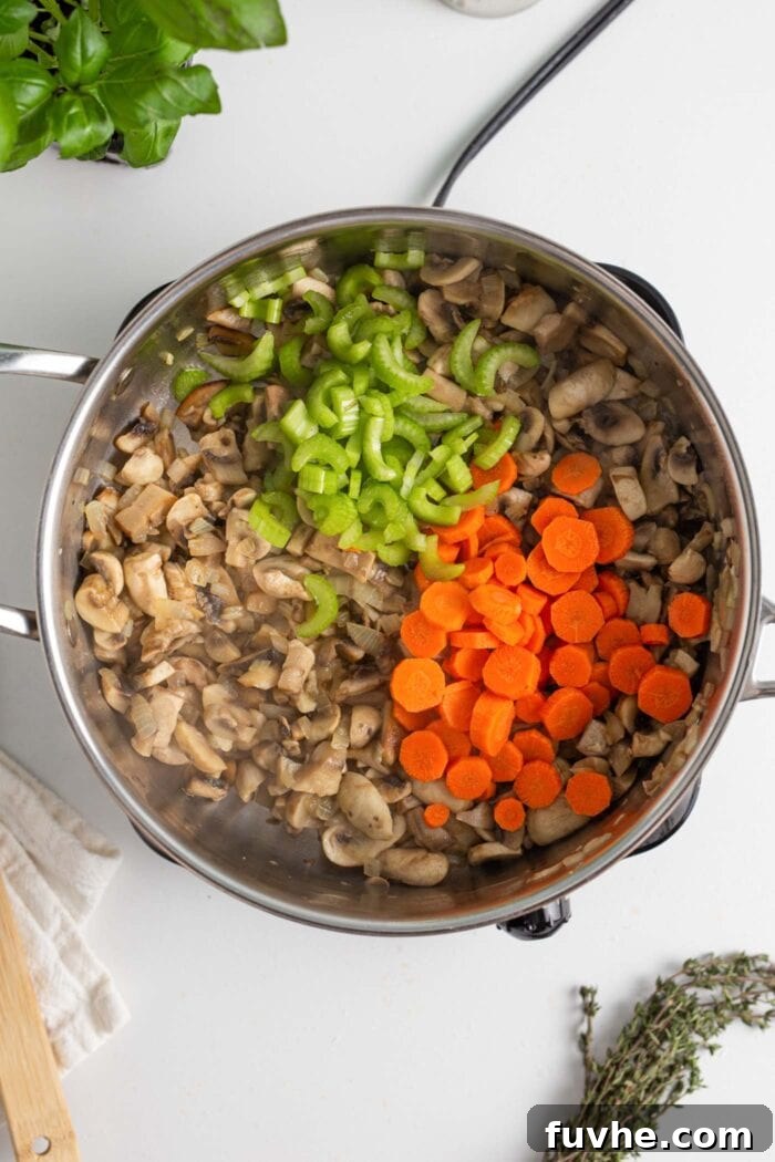 Hearty Vegan Mushroom Bolognese 5 Diced carrots and celery in a skillet with cooked mushrooms.