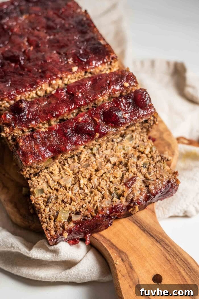 A close-up view of a perfectly sliced vegan nut roast, revealing its rich, textured interior and inviting aroma.