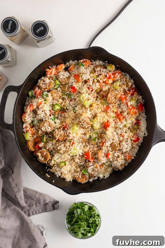 Rice, bell peppers, and various spices cooking in a skillet, filling the air with aromatic fragrance.