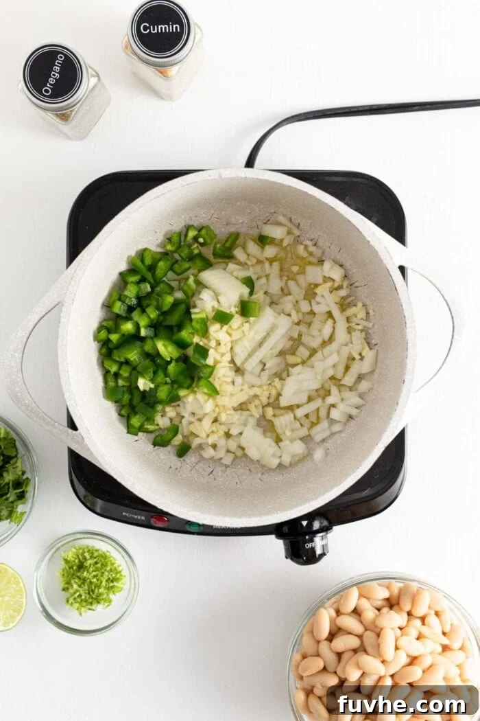 Creamy Vegan White Bean Chili 4 Jalapeno, garlic and onion cooking in a large soup pot, fragrant and tender.