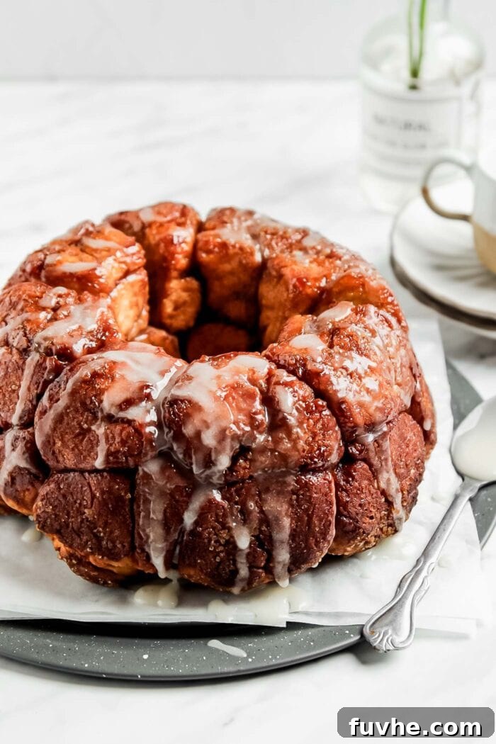Close up of a golden-brown, glazed vegan monkey pull-apart bread on a plate, ready to be enjoyed.