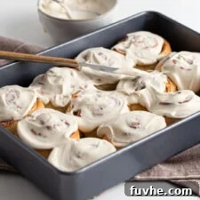 Beautifully iced vegan cinnamon buns arranged in a baking pan, ready to be enjoyed.
