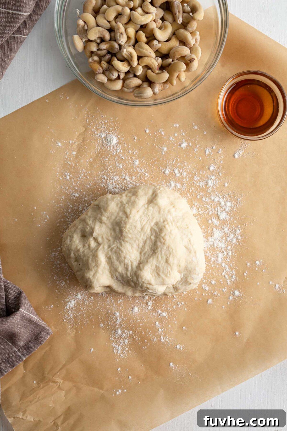 Smooth, elastic cinnamon roll dough resting on a lightly floured countertop, shaped into a perfect ball.