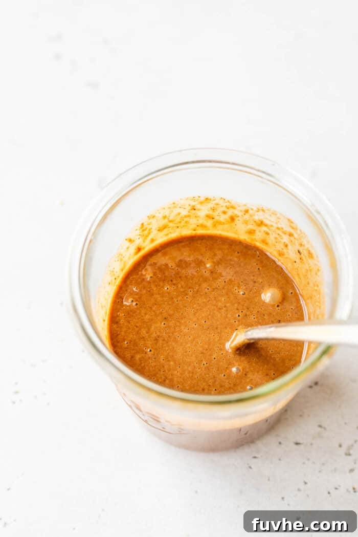 Refreshing Asian Peanut Noodles 6 Creamy peanut sauce in a glass jar with a spoon.