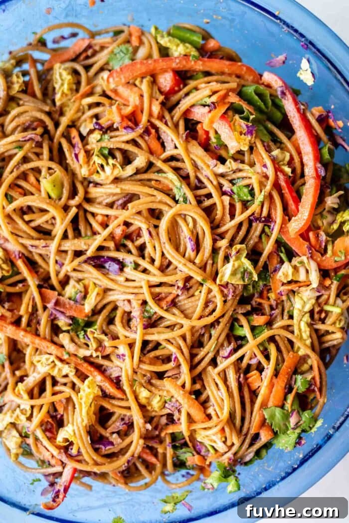 Refreshing Asian Peanut Noodles 7 A peanut noodle salad with chopped vegetables in a large mixing bowl.