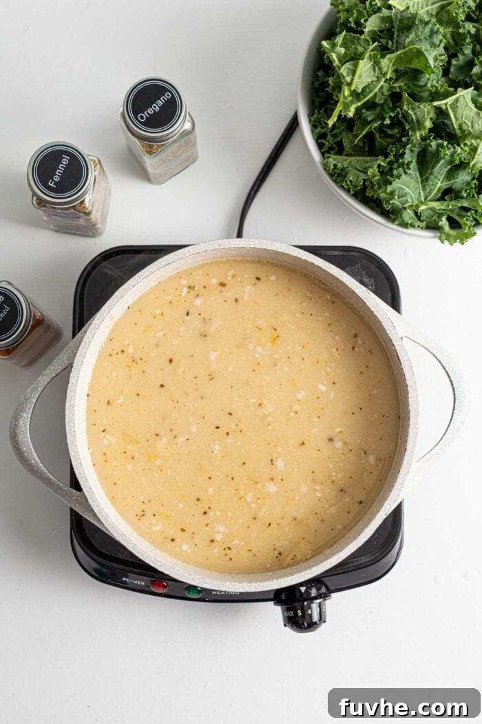 Creamy Plant Based Zuppa Toscana 7 A creamy, blended soup base simmering gently in a pot on a stovetop, ready for the next additions.