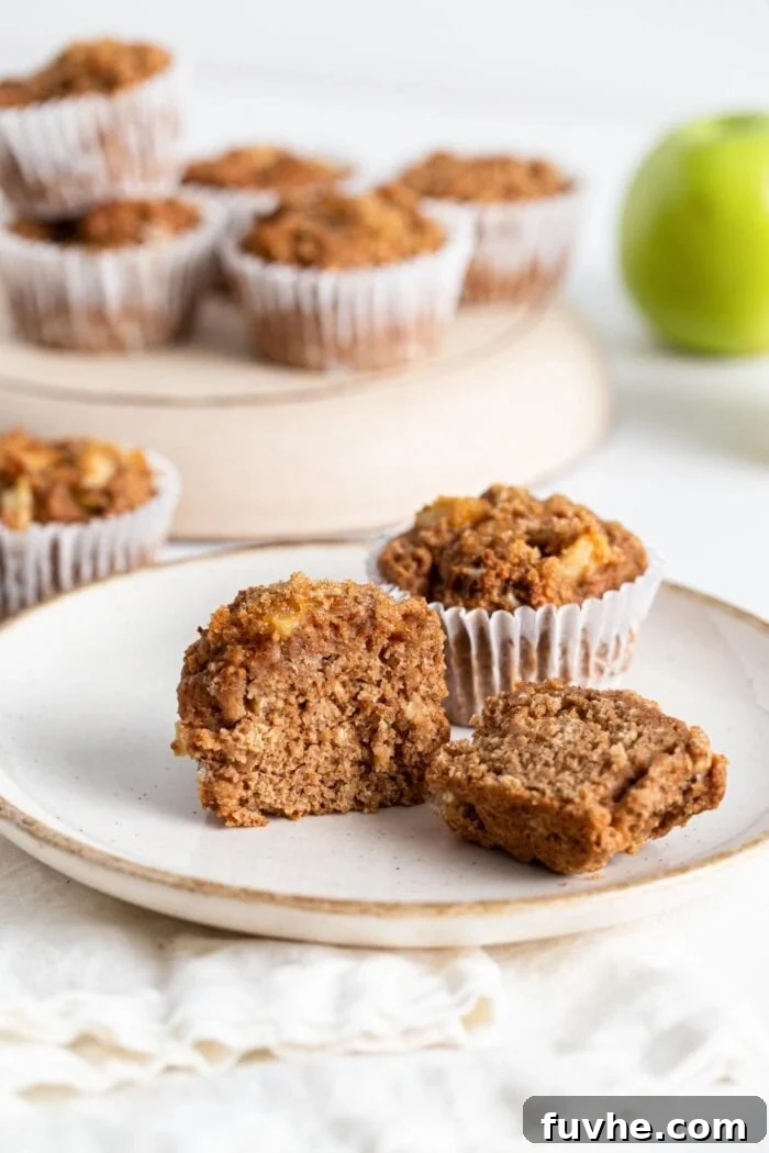 Sliced open applesauce muffin on a plate.