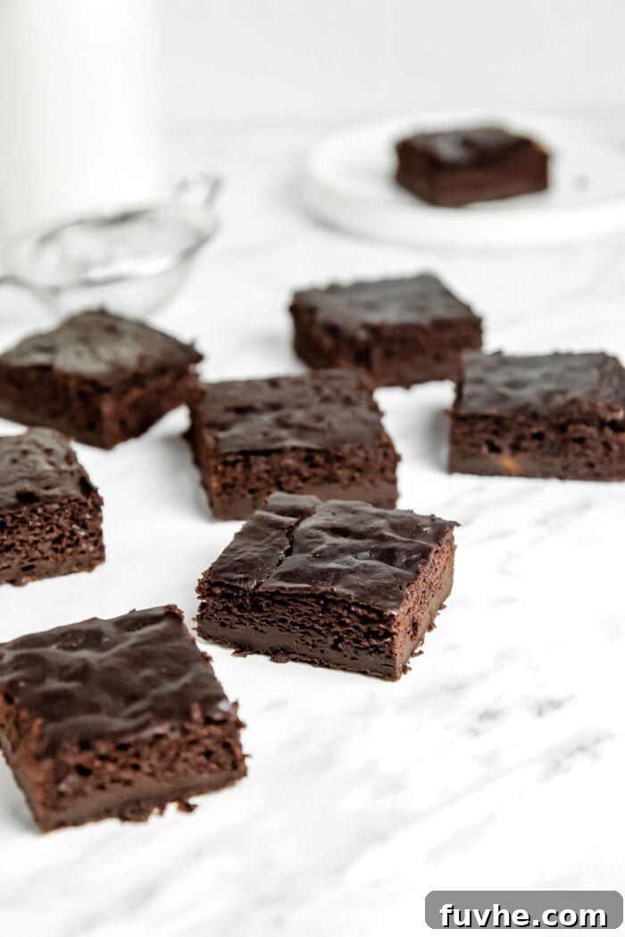 A perfectly arranged grid of sliced vegan sweet potato brownies on a marble surface, showcasing their fudgy interior.