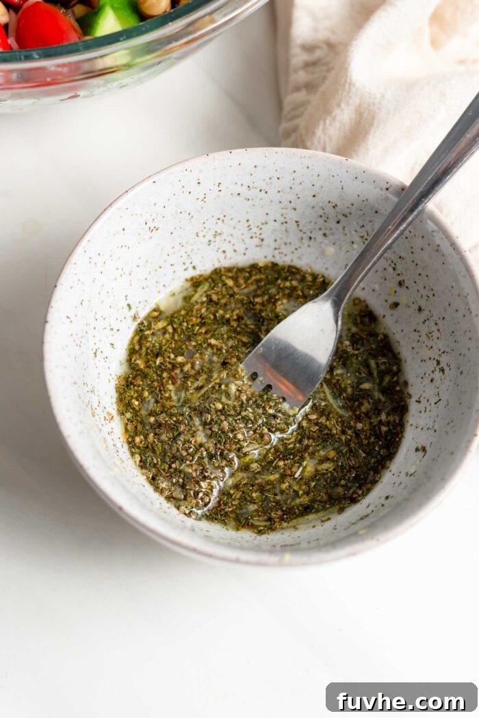 Herb salad dressing mixed in a small bowl with fork.