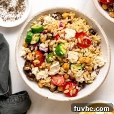 Overhead view of bowl of Mediterranean orzo salad with tomato, cucumber and olives.