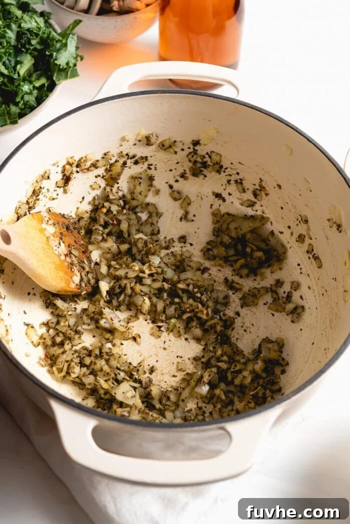 The chopped onions, garlic, and dried herbs sizzling gently in the pot, infusing the oil with their aromatic flavors.