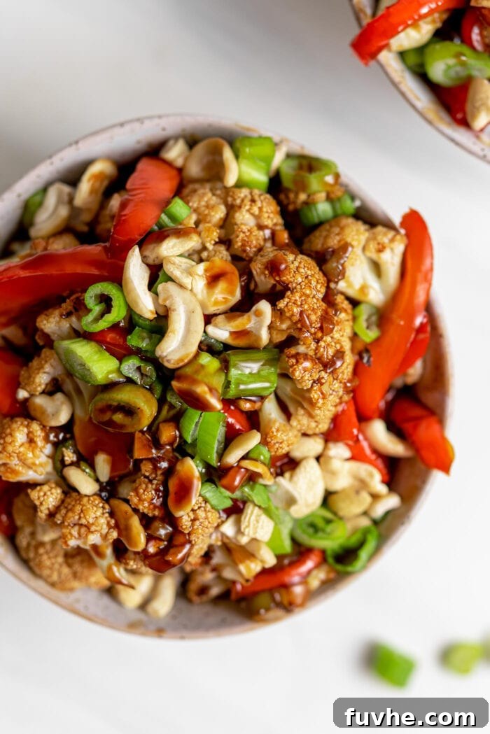 Crispy Kung Pao Cauliflower 7 Overhead view of a bowl of kung pao cauliflower with bell peppers, green onion and cashews