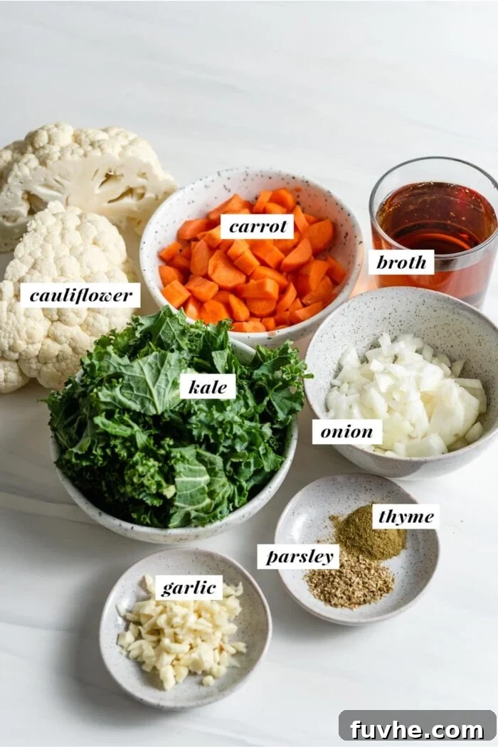 Visual of all fresh ingredients needed for making kale and cauliflower soup, neatly arranged.