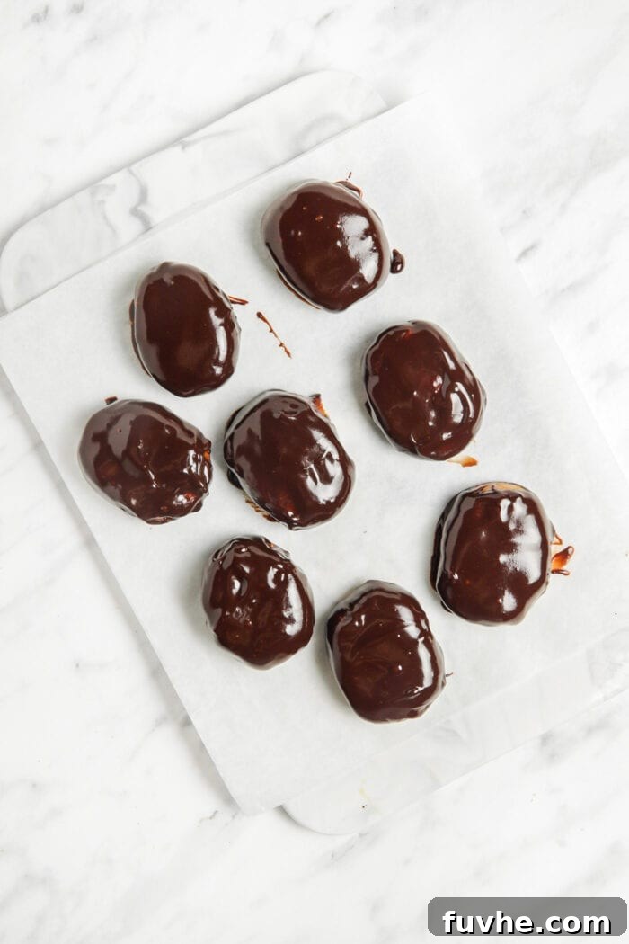 12 chocolate peanut butter eggs sitting on a piece of parchment paper.