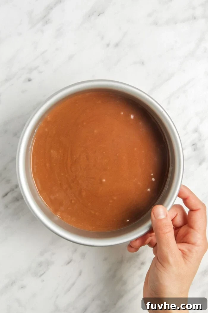 The rich, smooth raw chocolate cheesecake filling poured over the crust in a springform pan, ready for chilling.