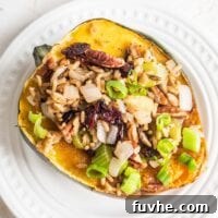 A brown rice, celery and cranberry stuffed acorn squash on a small white plate.