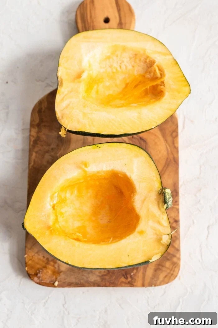 Golden Acorn Feast 4 Acorn squash cut in half with the seeds scooped out, ready for seasoning.
