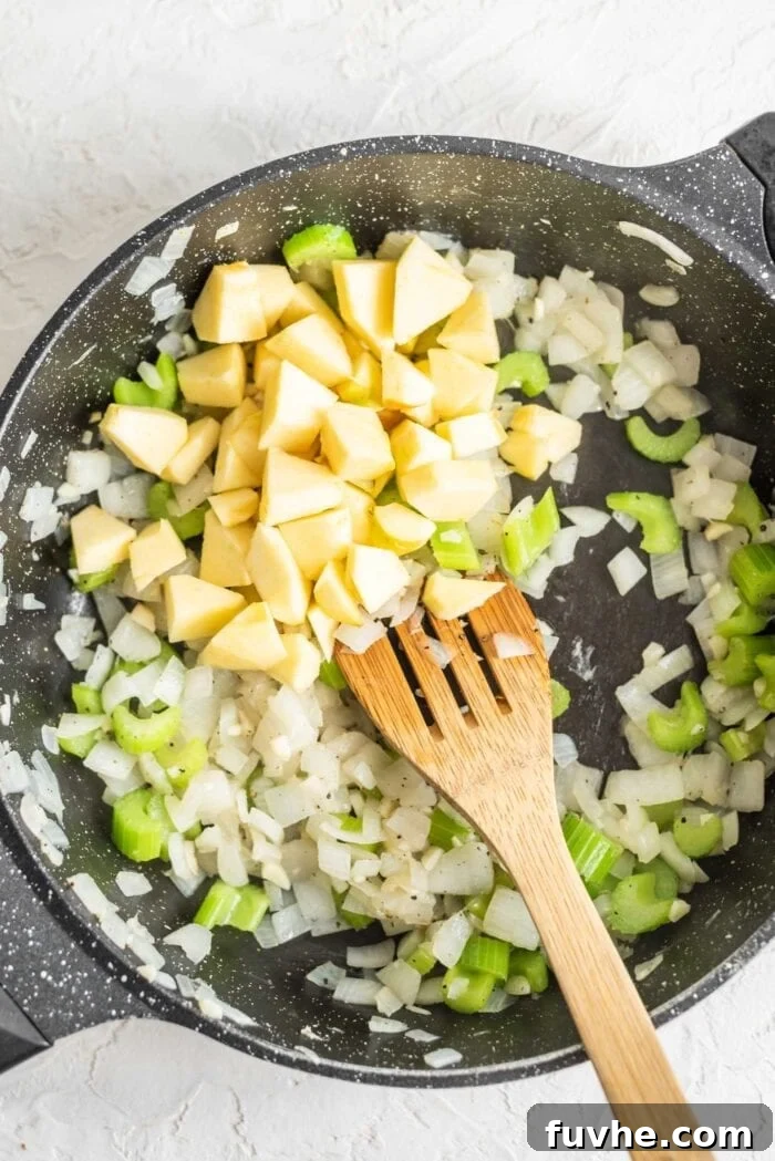 Golden Acorn Feast 8 Apple, celery, onion and garlic in a skillet with herbs, simmering gently.