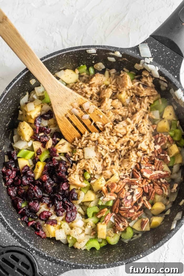Golden Acorn Feast 9 Rice, pecans, cranberries, apple and celery in a skillet, after combining all stuffing ingredients.