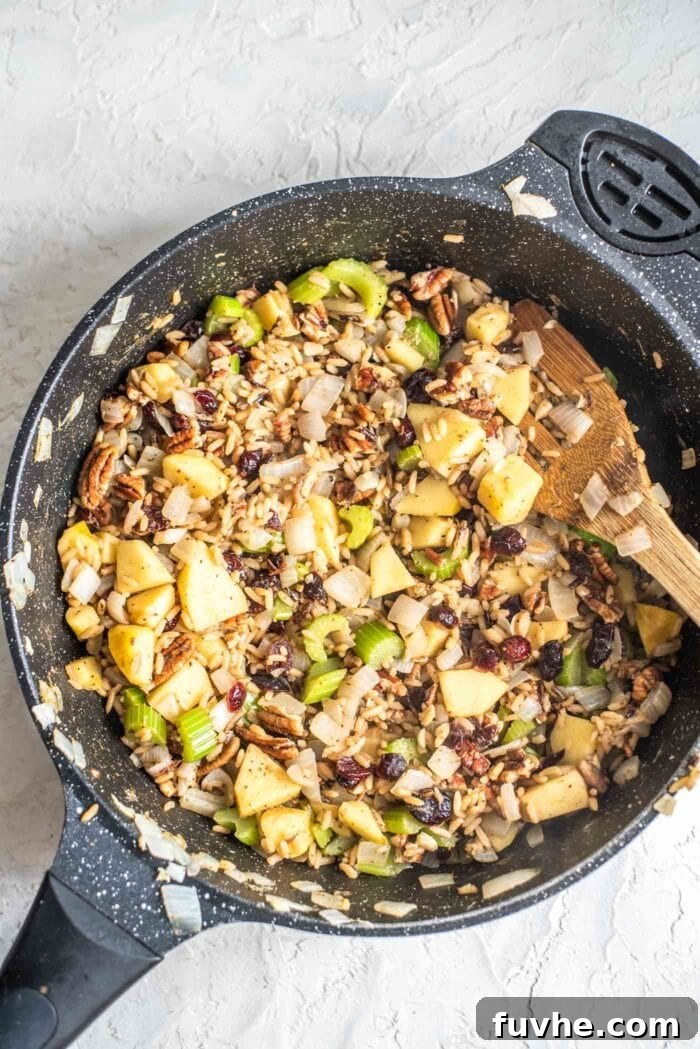 Golden Acorn Feast 10 Rice, pecans, cranberries, apple and celery in a skillet, showing the full, vibrant stuffing.