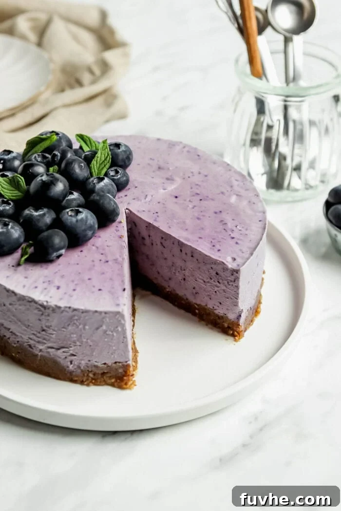 A stunning no-bake blueberry cheesecake with a slice elegantly cut out, revealing its rich purple layers and tempting texture, ready to be enjoyed.