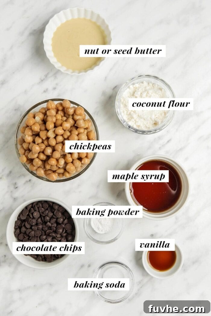 Visual ingredient list for making a chickpea blondie recipe, showcasing a can of chickpeas, almond butter, maple syrup, and chocolate chips.