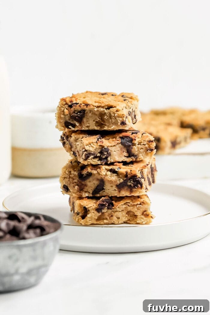 A stack of 4 small squares of chickpea chocolate blondies on a small plate, ready to be enjoyed.