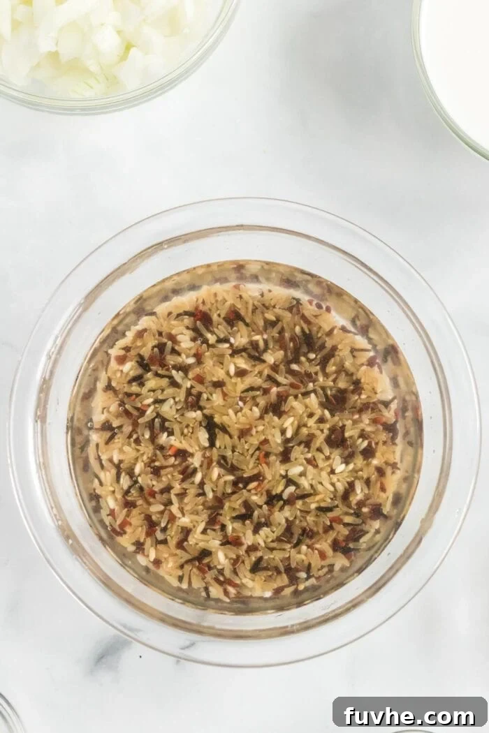 Close-up of wild rice grains soaking in a bowl of cold water, preparing for their role in the hearty soup.