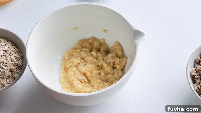 Superfood Quinoa Energy Bars 4 Mashed banana in a ceramic mixing bowl.