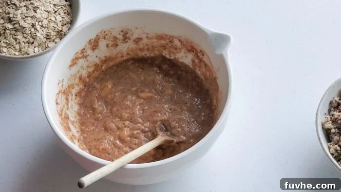 Superfood Quinoa Energy Bars 5 Batter in a mixing bowl with a wooden spoon in it.
