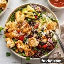 Overhead view of a roasted cauliflower burrito bowl with rice, roasted cauliflower, avocado and black beans.